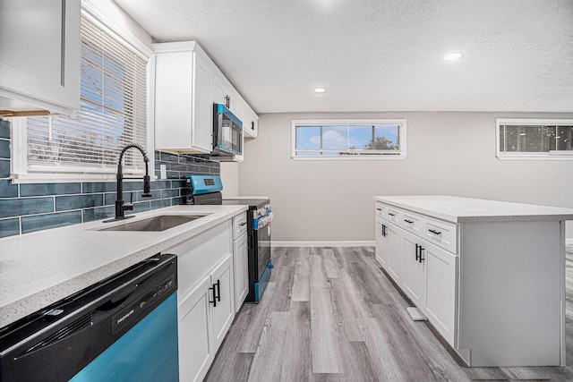 kitchen with sink, stainless steel dishwasher, backsplash, black / electric stove, and white cabinets