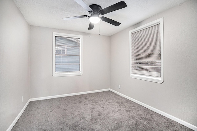 carpeted empty room featuring ceiling fan and a textured ceiling