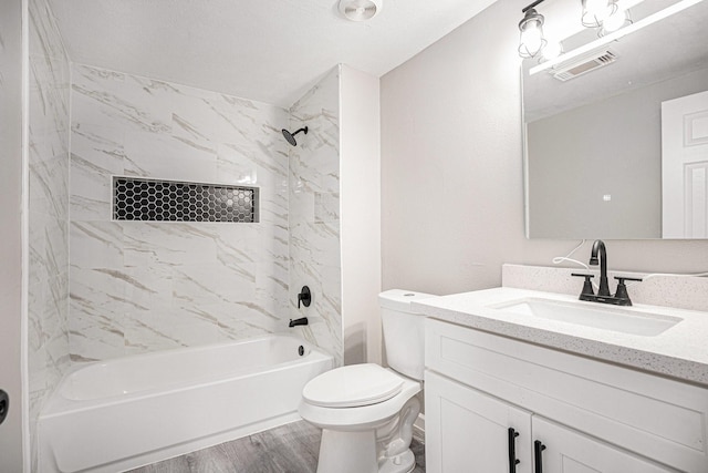 full bathroom featuring hardwood / wood-style floors, vanity, toilet, and tiled shower / bath