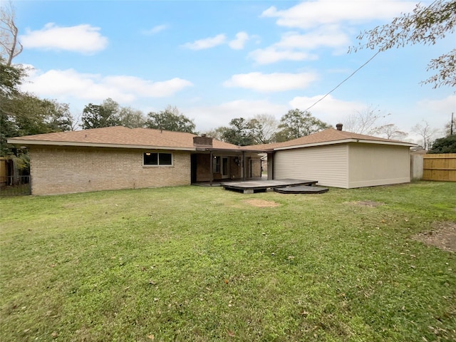 back of property with a lawn and a wooden deck