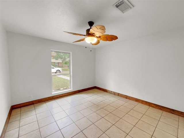 spare room with ceiling fan and light tile patterned flooring