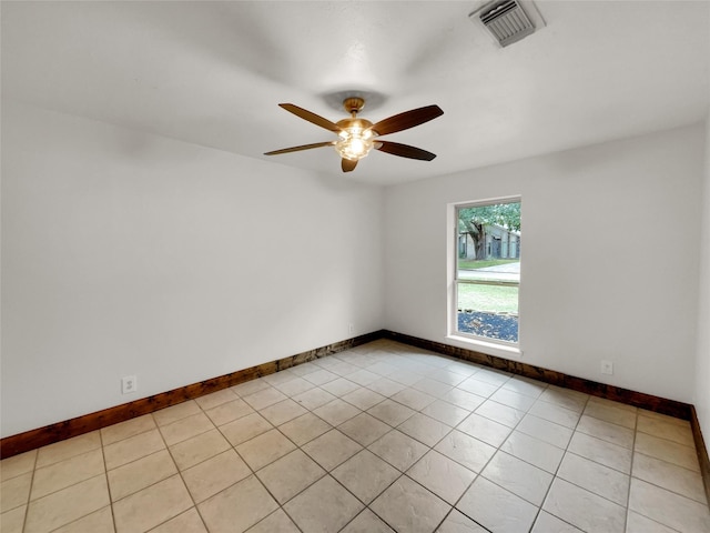 tiled spare room with ceiling fan