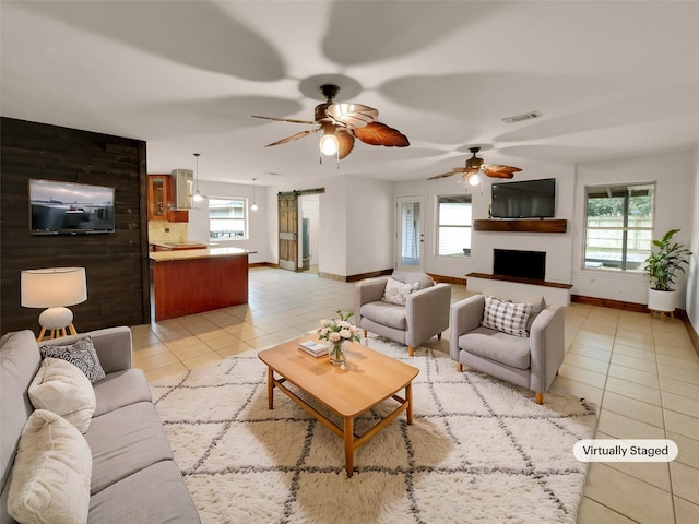 tiled living room featuring plenty of natural light and a large fireplace