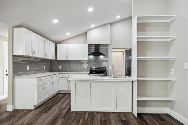 kitchen featuring stainless steel electric stove, white cabinets, wall chimney range hood, sink, and vaulted ceiling