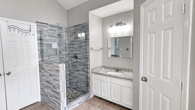 bathroom with tile patterned flooring, vanity, and a shower with door