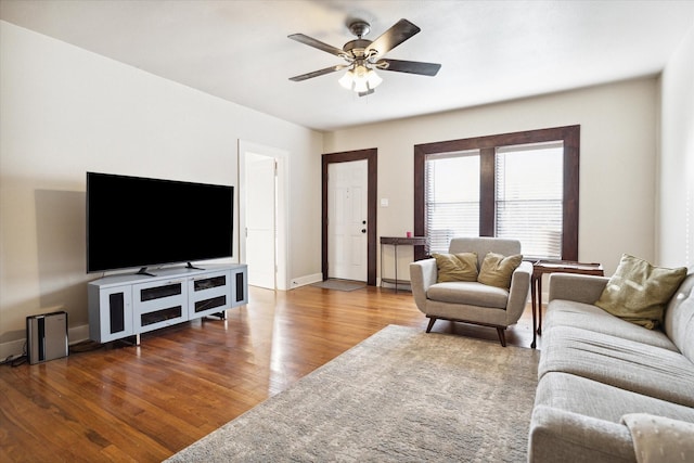 living room with ceiling fan and dark wood-type flooring