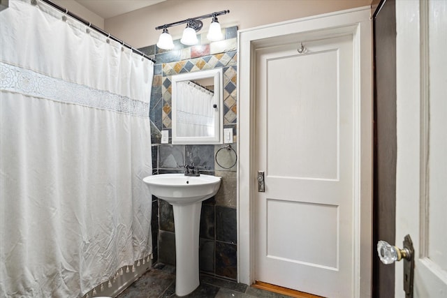 bathroom featuring sink and tile walls