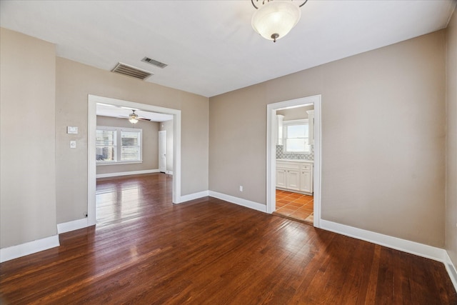 unfurnished room with ceiling fan and dark wood-type flooring