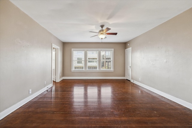 empty room with ceiling fan and dark hardwood / wood-style flooring