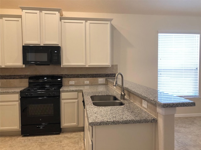 kitchen with white cabinetry, sink, light stone counters, kitchen peninsula, and black appliances