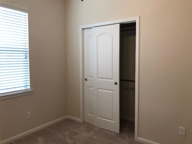 unfurnished bedroom with a closet and carpet floors