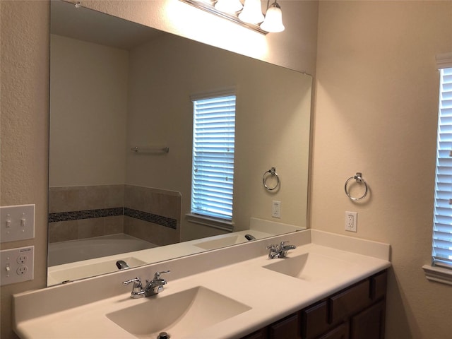 bathroom with vanity and a tub