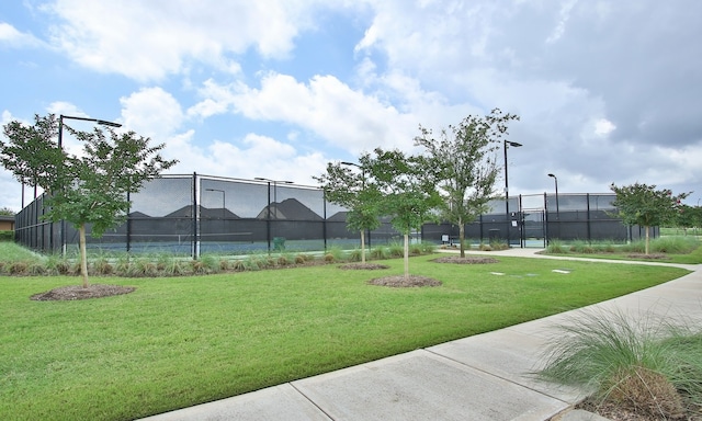 surrounding community featuring a lawn and tennis court