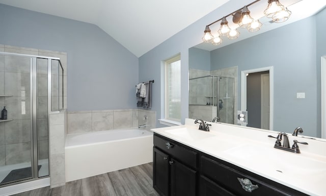 bathroom featuring shower with separate bathtub, vanity, hardwood / wood-style flooring, and vaulted ceiling