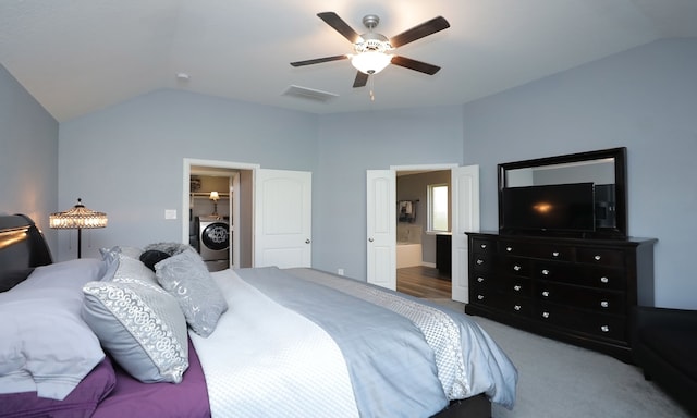 carpeted bedroom with ceiling fan, washer / dryer, ensuite bath, and vaulted ceiling