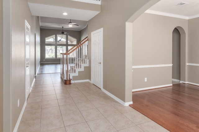 entrance foyer featuring crown molding, light tile patterned flooring, and ceiling fan