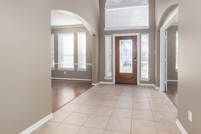 foyer featuring light tile patterned floors and ornamental molding