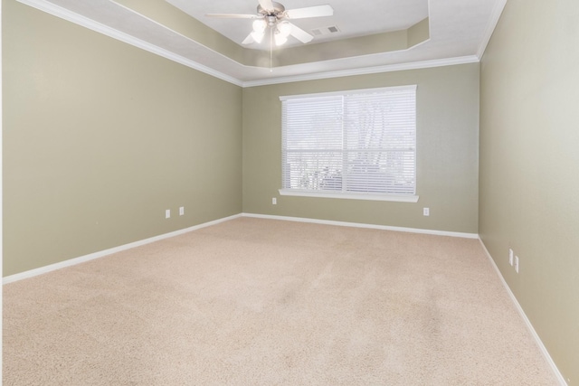 carpeted empty room with a tray ceiling, ceiling fan, and crown molding