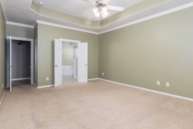 unfurnished bedroom featuring a raised ceiling, ceiling fan, light carpet, and ornamental molding