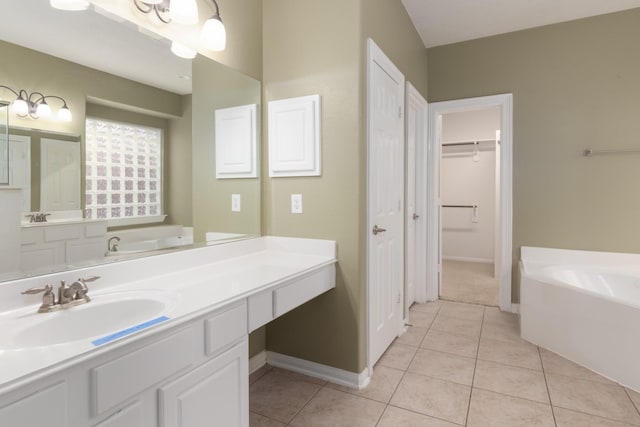 bathroom featuring a tub to relax in, tile patterned floors, and vanity