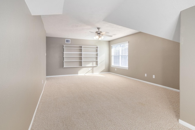 interior space with ceiling fan, carpet floors, and vaulted ceiling