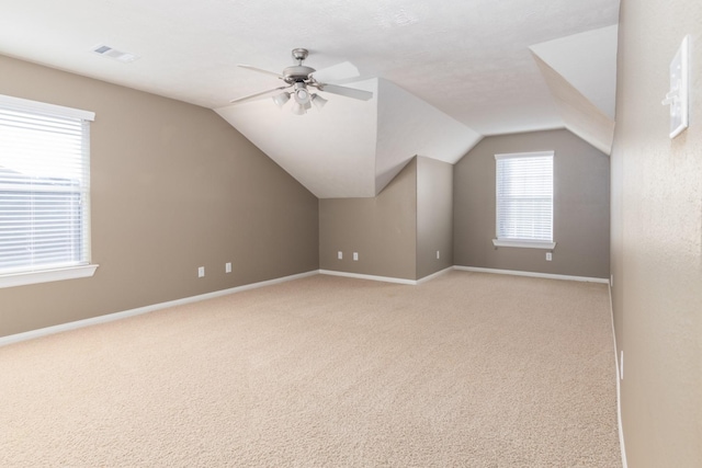 bonus room featuring ceiling fan, light carpet, and vaulted ceiling