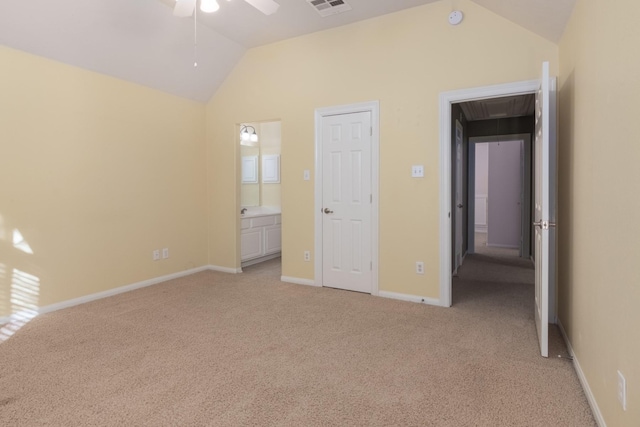 unfurnished bedroom with vaulted ceiling, light colored carpet, and ensuite bath