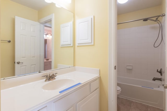 full bathroom featuring tile patterned floors, vanity, tiled shower / bath combo, and toilet