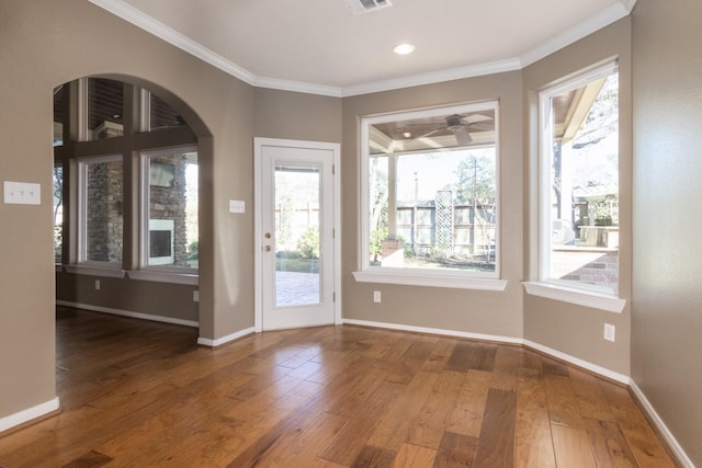 doorway to outside with hardwood / wood-style floors, crown molding, ceiling fan, and a healthy amount of sunlight