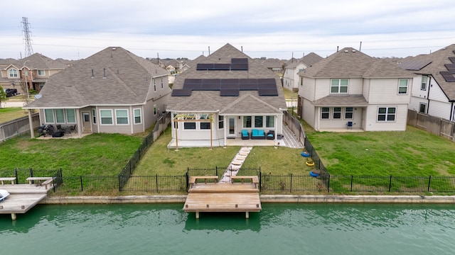 back of property featuring outdoor lounge area, a water view, and solar panels