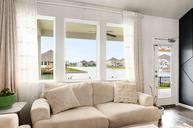 living room with wood-type flooring, a water view, and ceiling fan