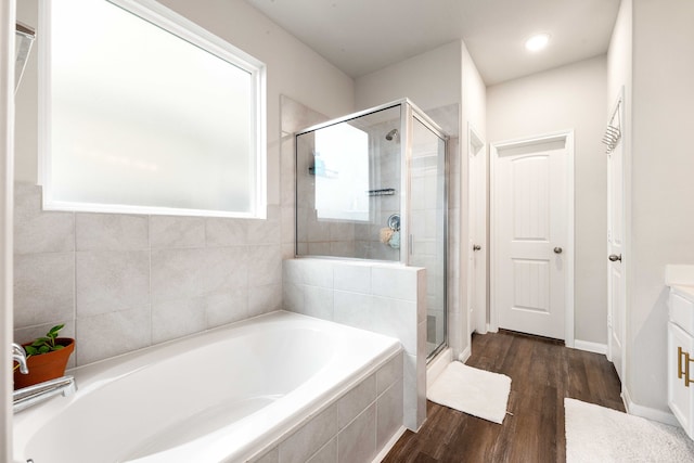 bathroom with vanity, hardwood / wood-style flooring, plenty of natural light, and independent shower and bath