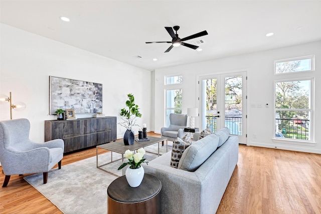 living room with ceiling fan, light hardwood / wood-style floors, and french doors