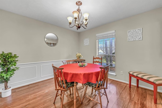 dining space with hardwood / wood-style floors and an inviting chandelier