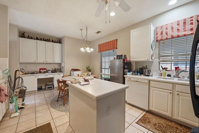 kitchen with pendant lighting, white dishwasher, stainless steel fridge, a kitchen island, and white cabinetry