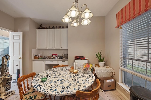 dining space with light tile patterned floors and an inviting chandelier