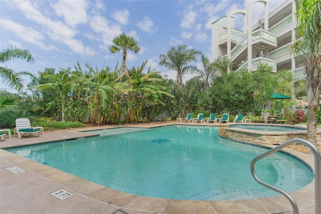 view of swimming pool featuring a hot tub