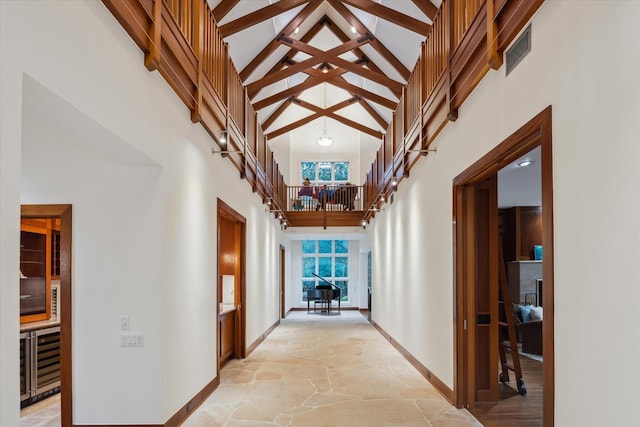 hallway featuring wine cooler, high vaulted ceiling, and beam ceiling