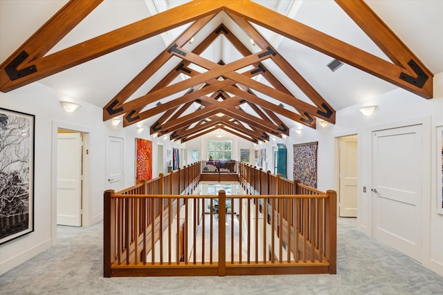 interior space with light carpet and lofted ceiling with beams