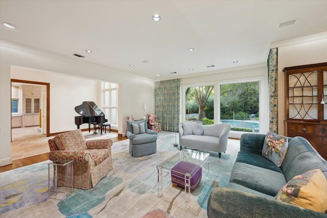 living room featuring crown molding and light hardwood / wood-style floors