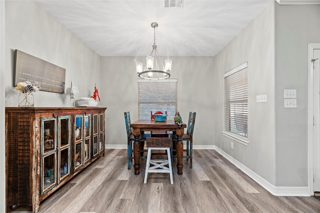 dining space featuring a chandelier and wood-type flooring