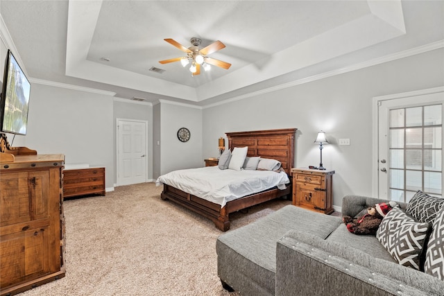 bedroom with a tray ceiling, crown molding, ceiling fan, and light colored carpet