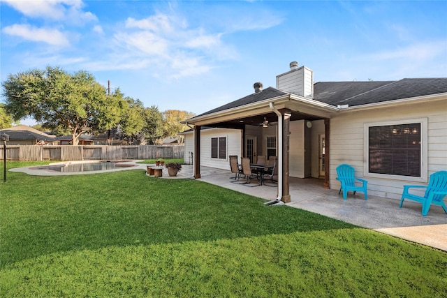 back of house featuring ceiling fan, a fenced in pool, a yard, and a patio