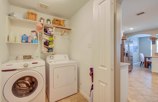 laundry area featuring independent washer and dryer and light tile patterned flooring