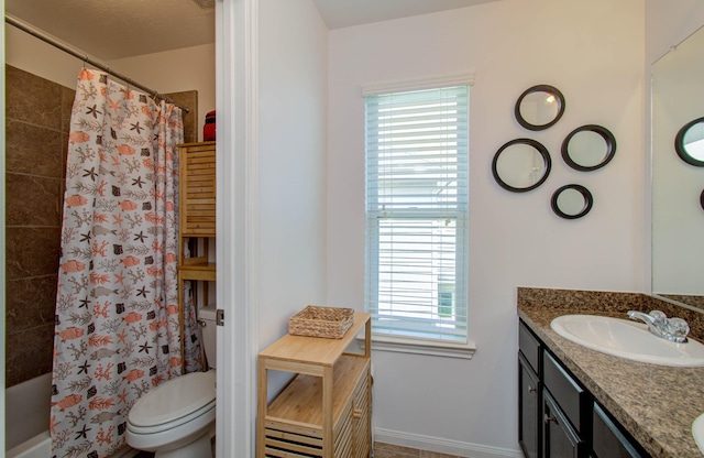 full bathroom with vanity, toilet, plenty of natural light, and shower / bath combo