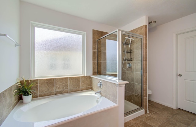 bathroom featuring toilet and independent shower and bath