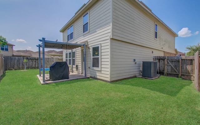 back of house featuring a yard, central AC, and a patio area