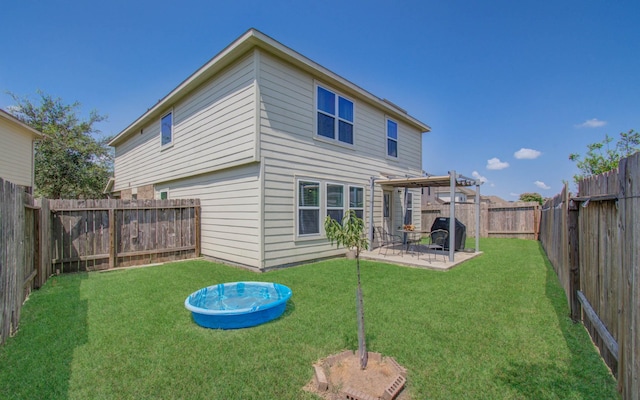 rear view of house featuring a yard and a patio