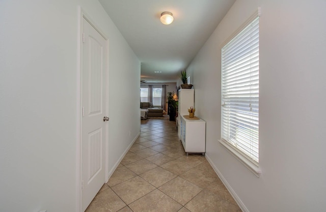 hall featuring a healthy amount of sunlight and light tile patterned floors