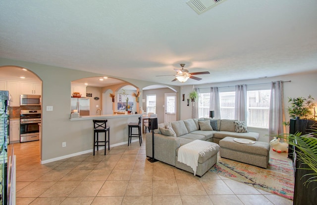 living room featuring light tile patterned floors and ceiling fan